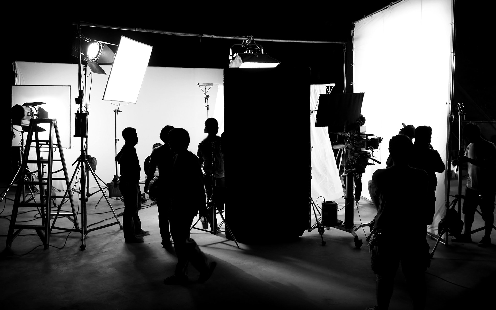 dark film set lights and crew silhouettes